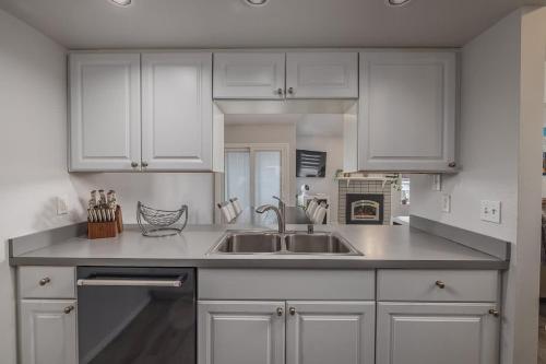 a kitchen with white cabinets and a sink at Charming Luxe Home Sleeps 4 in Anchorage