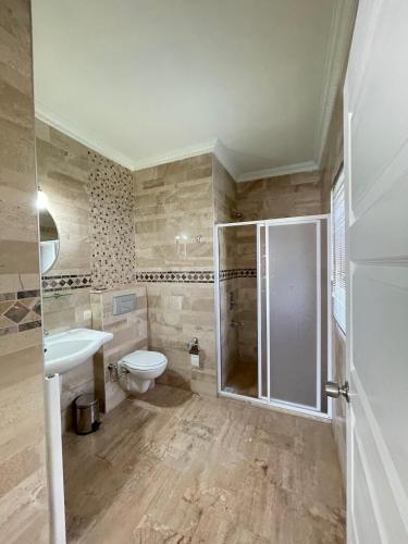 a bathroom with a shower and a toilet and a sink at Maison Edina - Cunda in Ayvalık
