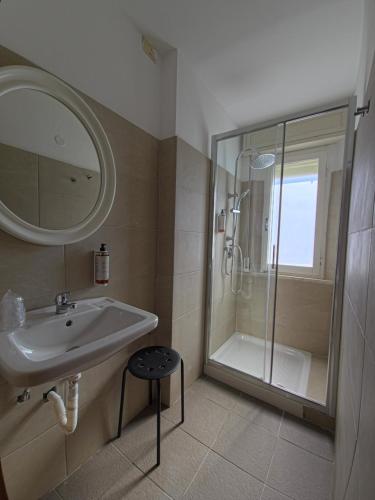 a bathroom with a sink and a shower with a mirror at Hotel Ornella in Bellaria-Igea Marina