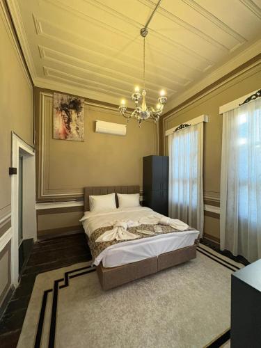 a bedroom with a bed and a chandelier at Avlia Konakları in Edirne
