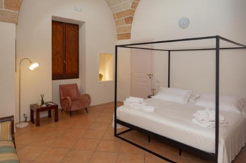 a bedroom with a canopy bed with a chair at Blu Rooms in Galatina