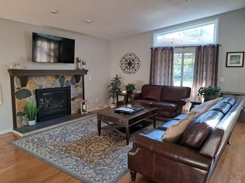 a living room with a couch and a fireplace at Lake Melissa Cabin on the Commons in Detroit Lakes