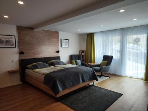 a bedroom with a large bed and a chair at Kleines Moselchalet in Cochem
