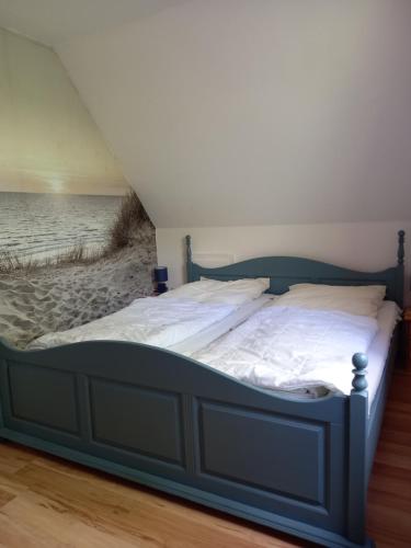 a bed in a room with a beach mural at Ferienwohnung Kreider in Dagebüll