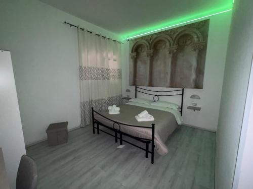 a bedroom with a bed with a green light at Il piccolo tempio di Ely in Termoli