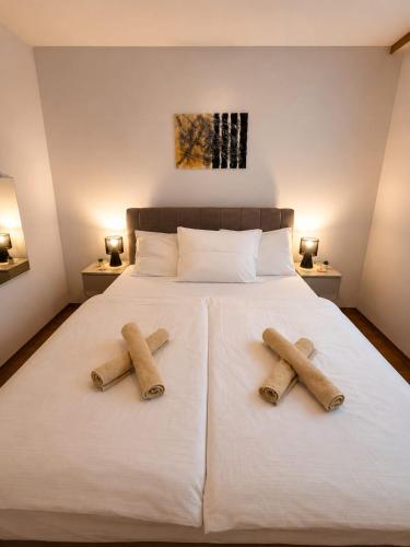 two towels on top of a bed with two pillows at App LOLLY in Selce