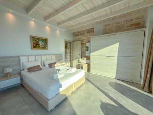 a bedroom with a large white bed and a bathroom at Paleokastro Villas with Private Heated Pool, Top Views - Next To Center - Top WiFi in Kissamos