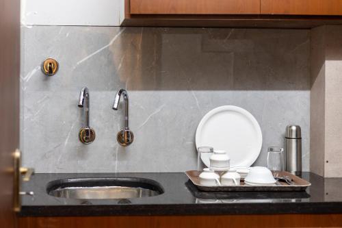 a kitchen counter with a sink and two faucets at Lumina Stays-Modern Luxury Rooms, Near NAD in Visakhapatnam