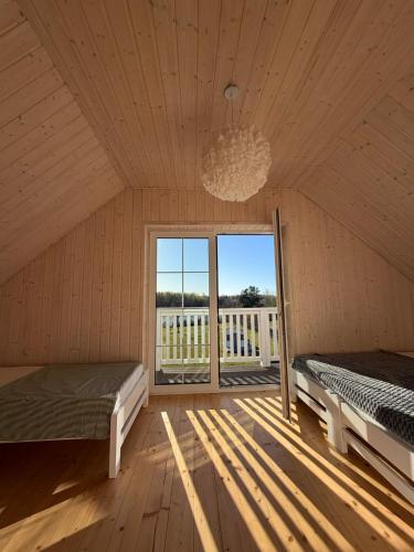 a bedroom with two beds and a large window at Przystanek Dobra in Dobra