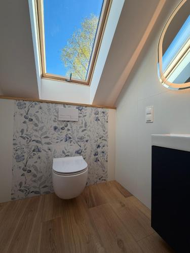 a bathroom with a toilet and a window at Przystanek Dobra in Dobra