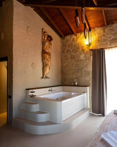 a bath tub with a statue of a woman on the wall at LA BİEN ALAÇATI by ALİİS in Çeşme