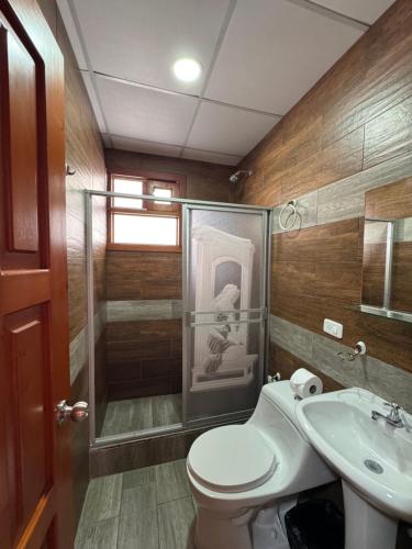a bathroom with a toilet and a shower and a sink at Playita Salomon in Baños