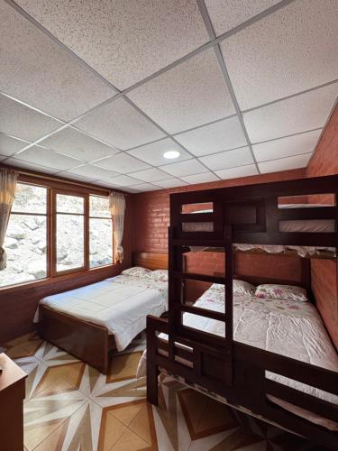 a bedroom with two bunk beds and a window at Playita Salomon in Baños