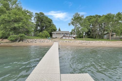 a dock in the water with a house in the background at Amazing Grace Etta Shores in Henning