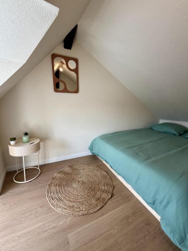 a bedroom with a bed and a table and a rug at Le B - Appartement centre ville en duplex in Rennes