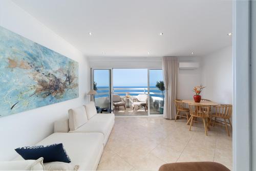 a living room with a white couch and a table at Lighthouse - Exclusive Sea view 180º, pool, parking in Portimão