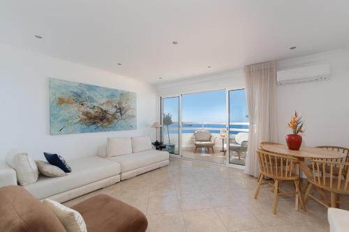 a living room with a couch and a table at Lighthouse - Exclusive Sea view 180º, pool, parking in Portimão