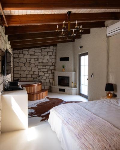 a bedroom with a large bed and a stone wall at LA BİEN ALAÇATI by ALİİS in Çeşme
