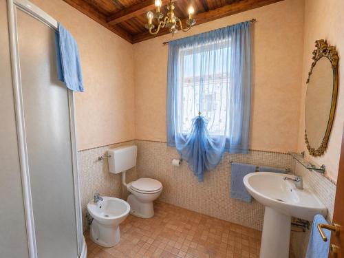 a bathroom with a toilet and a sink and a window at B&B Il Fiocinino in Comacchio