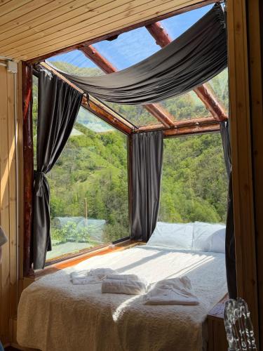 a bed in a room with a large window at Mountain Paradise in Merisi 2 in Merisi