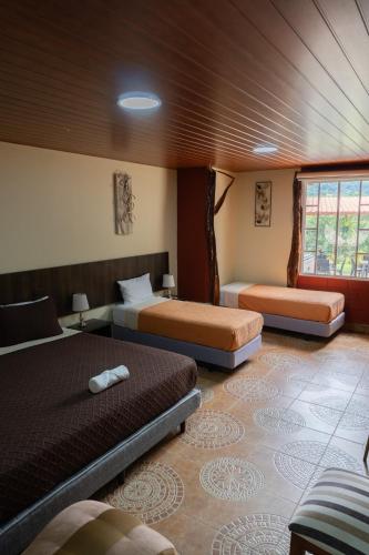 a bedroom with two beds in a room at Salamandras Hostería & Spa in Tena
