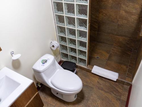 a bathroom with a toilet and a sink and a shower at Salamandras Hostería & Spa in Tena