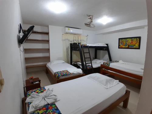 a room with three beds and a staircase at Hostal Princesa Katia in Necoclí