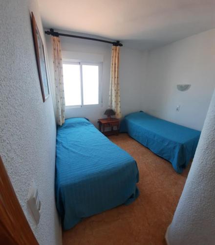 a bedroom with two beds and a window at Casa Gaia in La Manga del Mar Menor