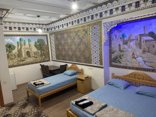 a room with two beds and a painting on the wall at MUXSIN s in Bukhara