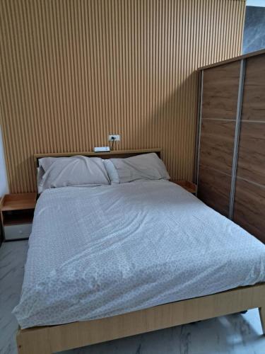 a bedroom with a large bed with a wooden headboard at City View Studio Pool - Gym - Caesar Residence in Mactan Island