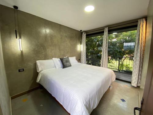 ein Schlafzimmer mit einem großen Bett und einem Fenster in der Unterkunft Hotel Casa Grangelo in Atlixco