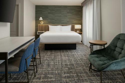 a hotel room with a bed and two chairs at TownePlace Suites by Marriott Reno in Reno