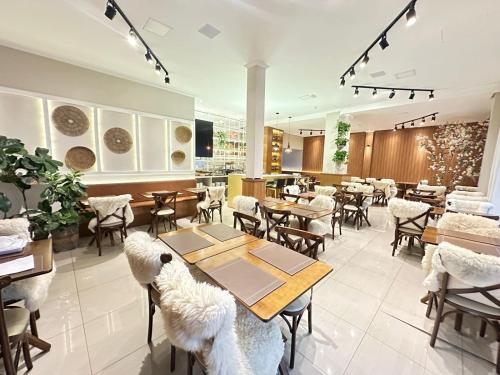 a restaurant with tables and chairs in a room at Zallon Hotel Executivo - Late Checkout Cortesia as 15hs aos DOMINGOS in Lajeado