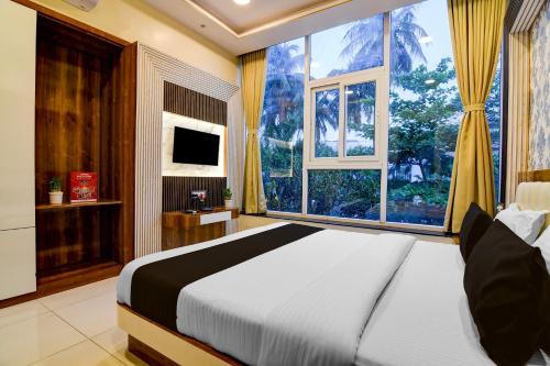 a bedroom with a large bed and a large window at Super Townhouse Hotel All In One in kolkata