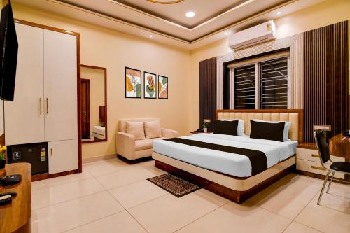 a bedroom with a bed and a chair in it at Super Townhouse Hotel All In One in kolkata