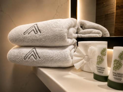 a pile of towels on a counter in a bathroom at Avanta Hotel & Villas Querétaro in Santa Rosa de Jáuregui