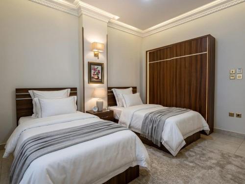 two beds in a hotel room with white sheets at Soly Apartments in Hurghada