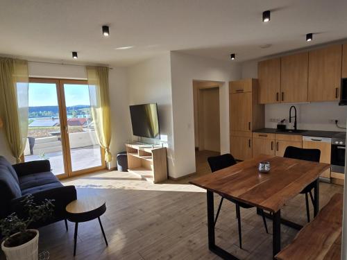 a living room with a table and a kitchen at RoSa Haus in Steingaden