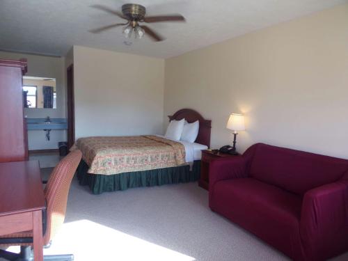 a hotel room with a bed and a couch at Huggy Bear Motel - Warren in Warren