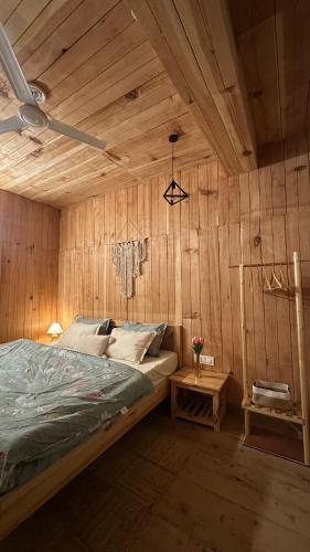 a bedroom with a bed and a wooden wall at Aroha Living in Bandal