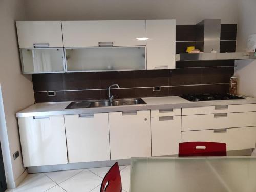 a kitchen with white cabinets and a sink at Dimora C&A in Mondragone