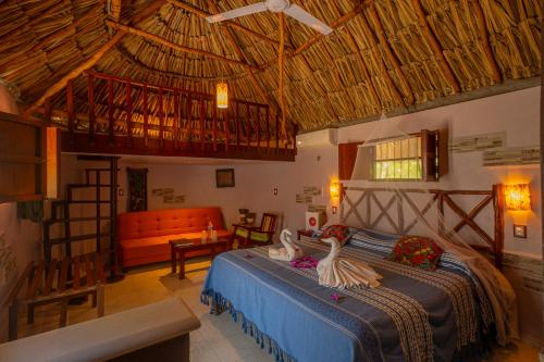ein Schlafzimmer mit einem Bett, auf dem zwei Schwäne abgebildet sind in der Unterkunft The Pickled Onion Hotel & Restaurant Uxmal in Santa Elena