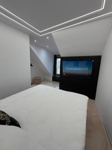 a bedroom with a bed and a flat screen tv at WOT Rose Residence in Arad