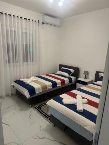 two beds in a room with white walls at Lux Villa Azur in Bar