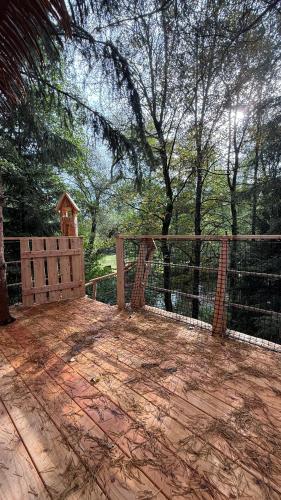 a patio with a fence and a gate and trees at Dům ve stromech nad řekou in Moravecké Pavlovice