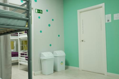 a room with a bunk bed and two trash cans at Augas Quentes Hostel in Ourense
