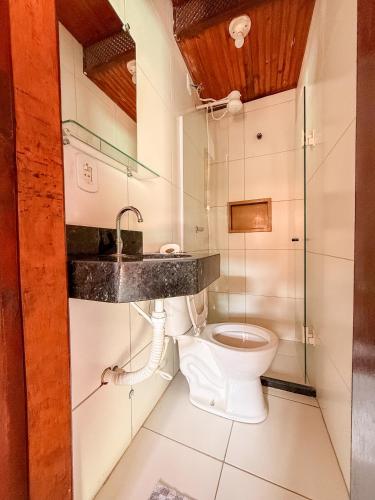 a bathroom with a toilet and a sink at Pousada Timbalada in Morro de São Paulo