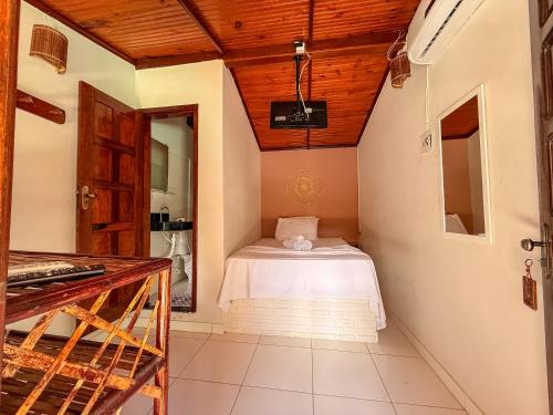 a small room with a bed in the corner of a room at Pousada Timbalada in Morro de São Paulo