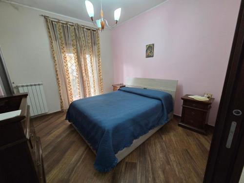 a bedroom with a bed with a blue bedspread at Holiday House Herculaneum in Ercolano