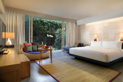 a bedroom with a bed and a living room at Cross Paasha Bali Seminyak in Seminyak